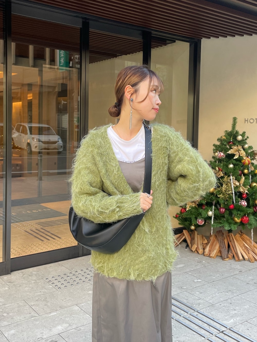 グリーン系のニット/セーター、ホワイト系のブーツを着用したレディースの秋コーディネートの4枚目の写真