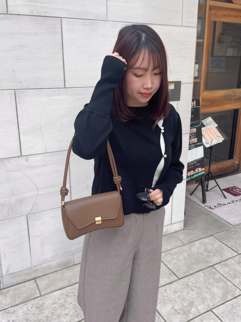 ブラック系のニット/セーター、ブラウン系のローファー、ベージュ系のその他パンツを着用したレディースの冬コーディネートの4枚目の写真