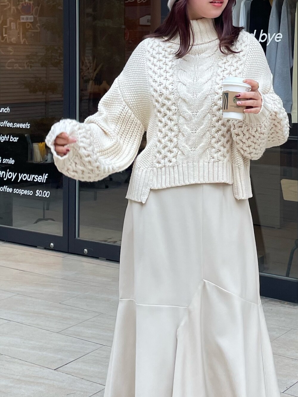 ホワイト系のニット/セーター、ホワイト系のスカートを着用したレディースの冬コーディネートの3枚目の写真