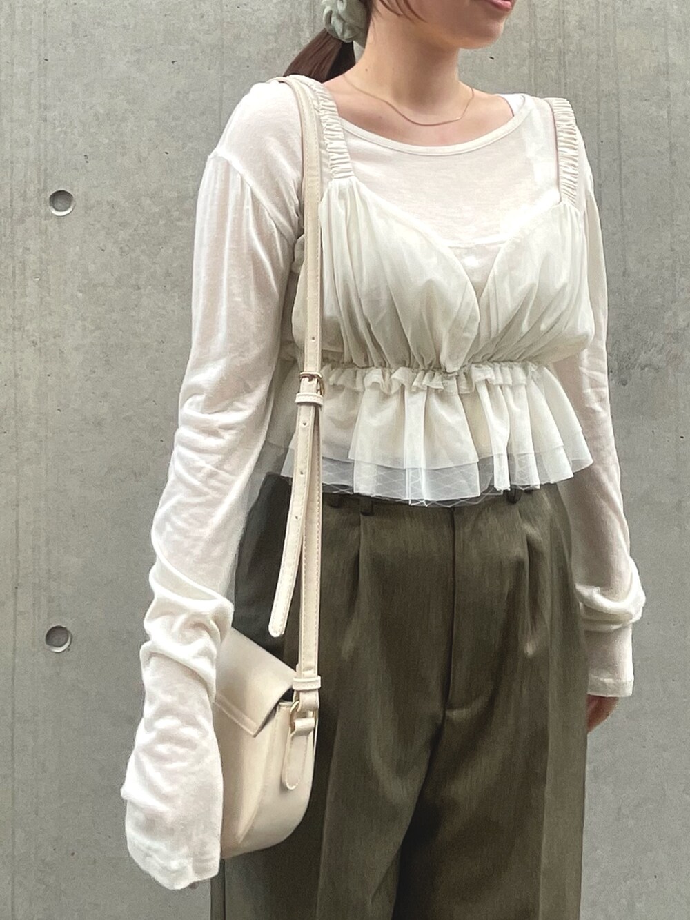 ブラウン系のスラックス、ホワイト系のキャミソールを着用したレディースの夏コーディネートの5枚目の写真