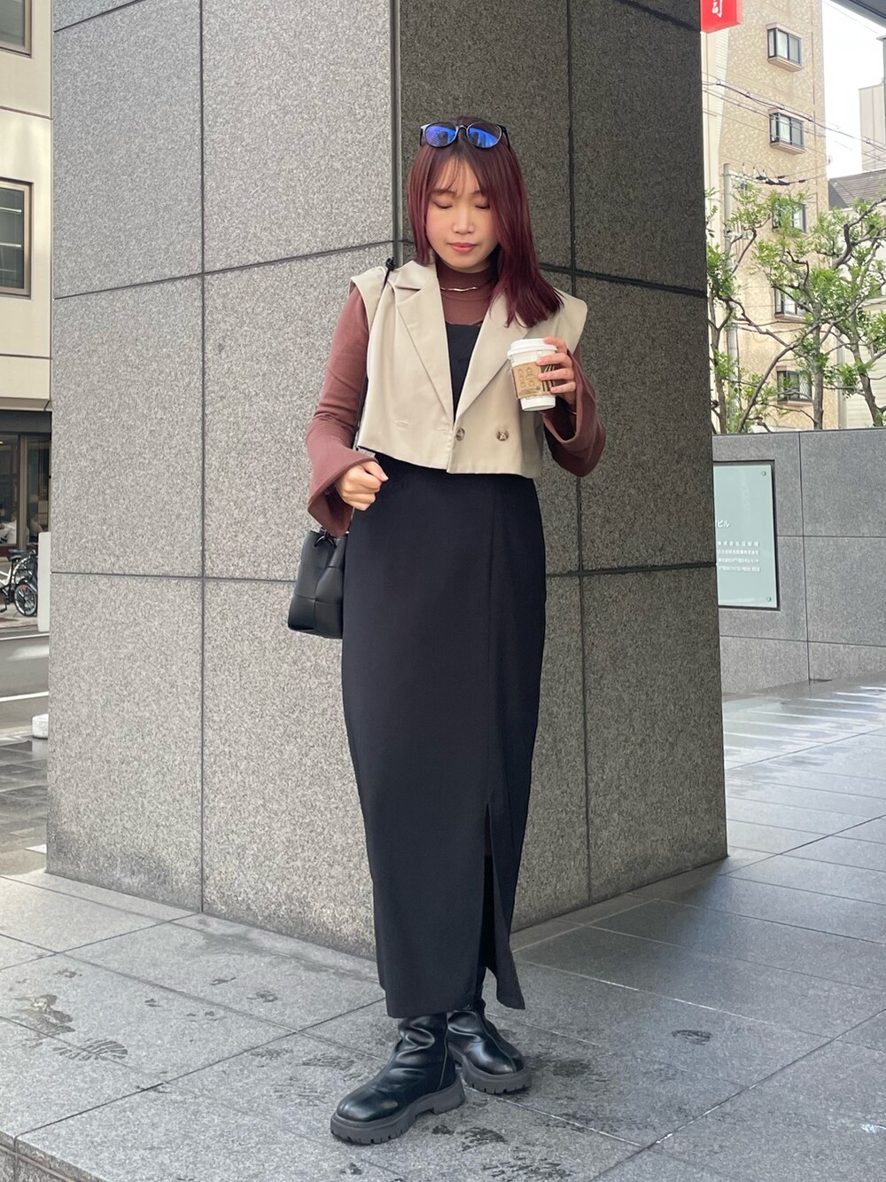 ブラウン系のニット/セーター、ブラック系のドレスを着用したレディースの冬コーディネートの2枚目の写真