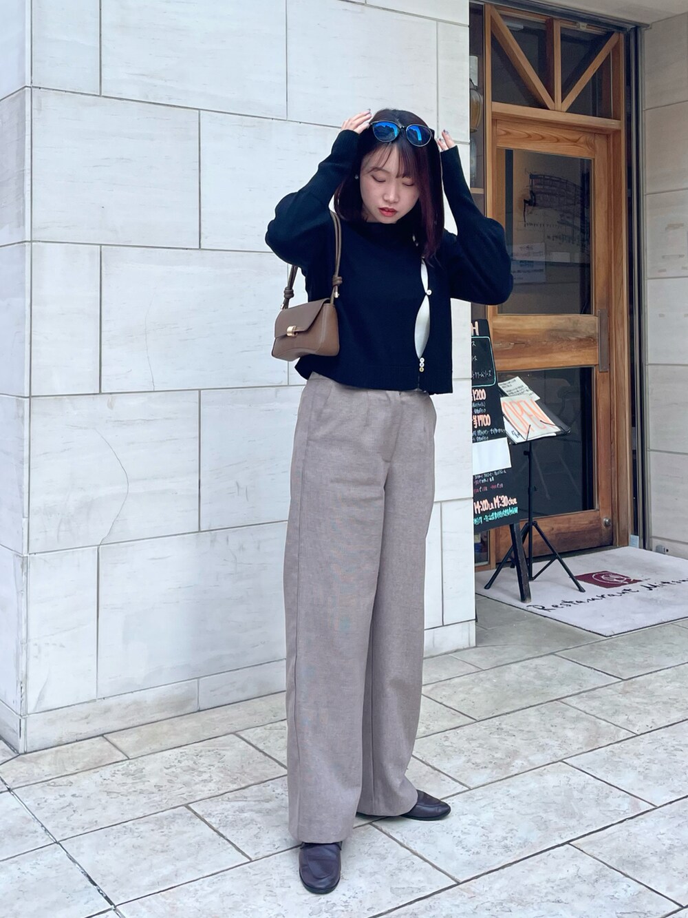 ブラック系のニット/セーター、ブラウン系のローファー、ベージュ系のその他パンツを着用したレディースの冬コーディネートの3枚目の写真