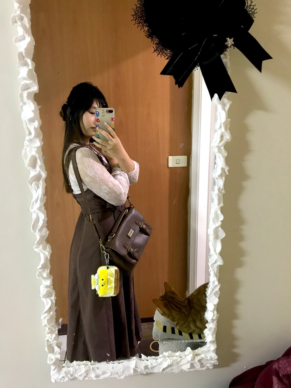 ブラウン系のショルダーバッグ、イエロー系のコインケースを着用したレディースの春コーディネートの2枚目の写真