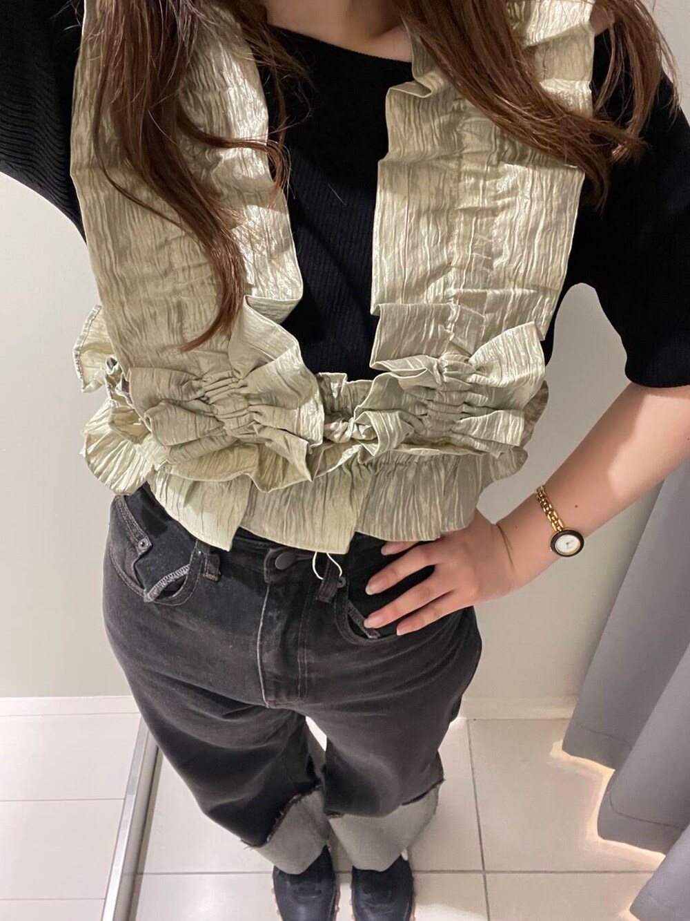 ブラック系のニット/セーター、ベージュ系のベスト、ブラック系のデニムパンツを着用したレディースの夏コーディネートの4枚目の写真