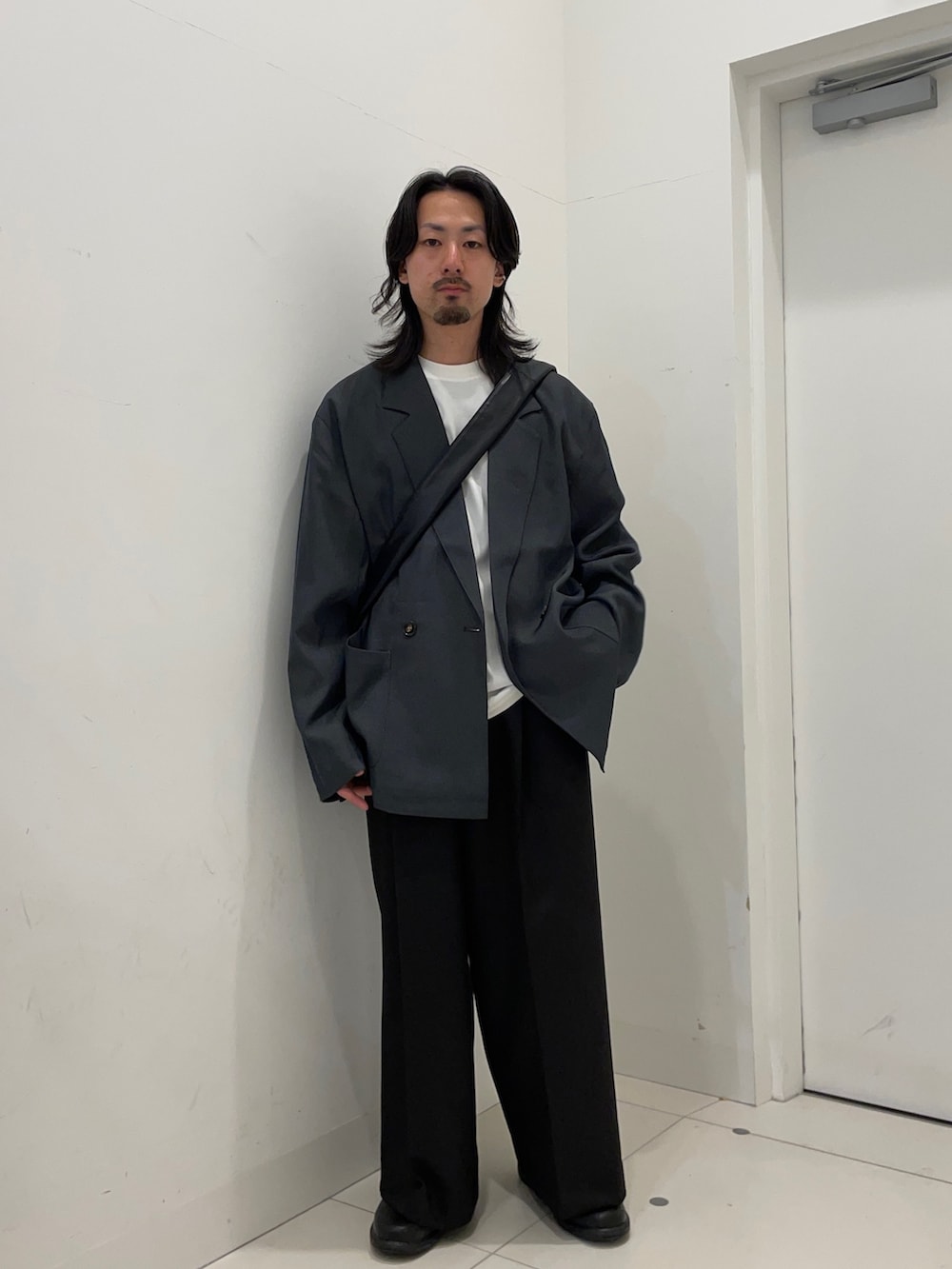 グレー系のその他アウター、ブラック系のその他パンツ、ブラック系のショルダーバッグを着用したメンズの秋コーディネートの2枚目の写真