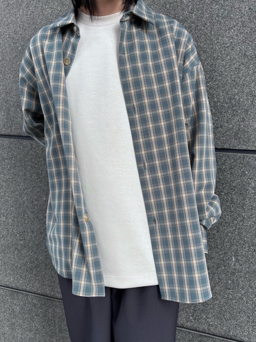 ホワイト系のTシャツ/カットソー、ブルー系のシャツ/ブラウス、グレー系のスラックスを着用したメンズの冬コーディネートの2枚目の写真