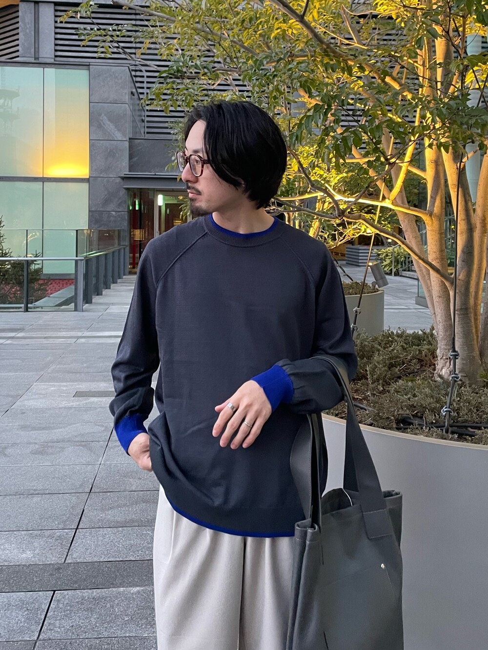 ベージュ系のその他パンツ、グレー系のトートバッグ、グレー系のニット/セーターを着用したメンズの春コーディネートの3枚目の写真