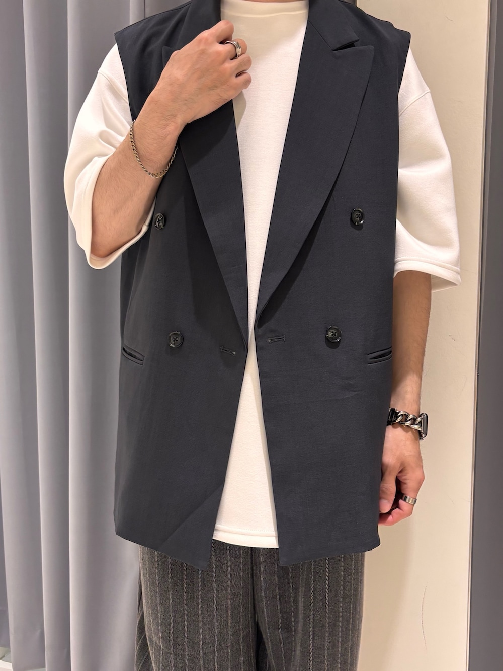 グレー系のダウンベスト、グレー系のその他パンツを着用したメンズの春コーディネートの2枚目の写真