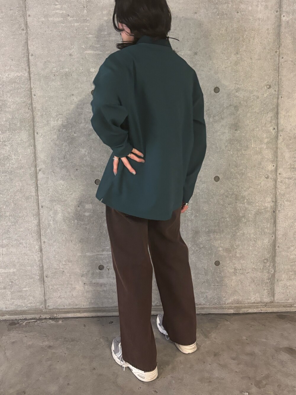 ブラウン系のデニムパンツ、グリーン系のポロシャツを着用したメンズの秋コーディネートの3枚目の写真