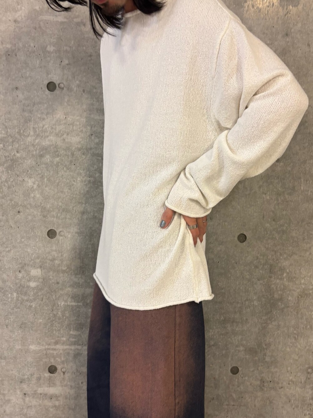 ホワイト系のニット/セーター、ブルー系のデニムパンツを着用したメンズの秋コーディネートの2枚目の写真