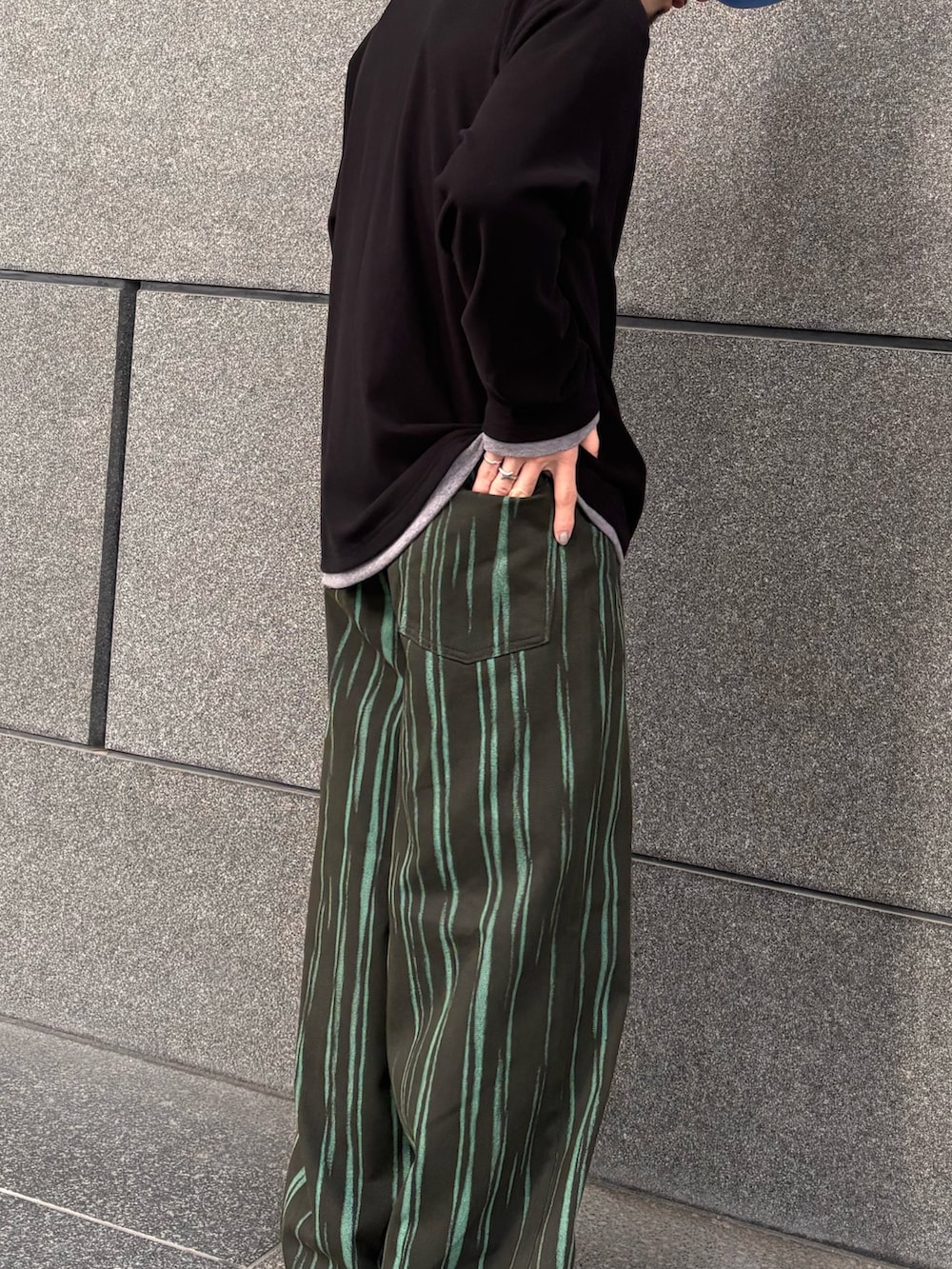 グリーン系のデニムパンツ、ブラック系のTシャツ/カットソーを着用したメンズの春コーディネートの2枚目の写真