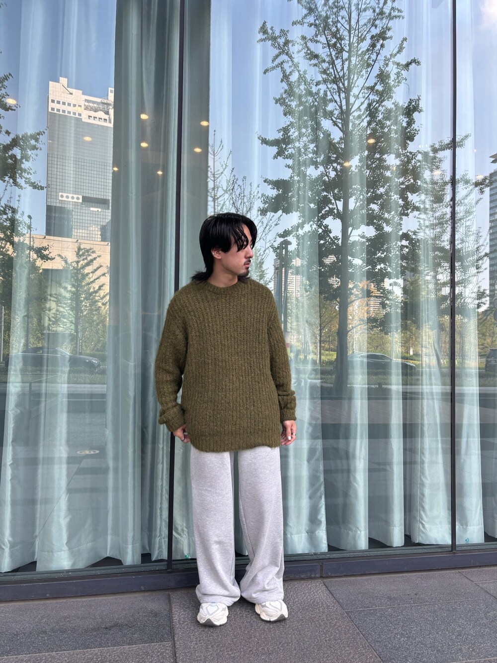 グリーン系のニット/セーター、グレー系のその他パンツを着用したメンズの秋コーディネートの3枚目の写真