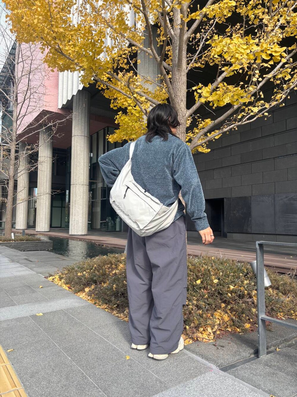 グレー系のショルダーバッグ、グレー系のその他パンツ、ブルー系のニット/セーターを着用したメンズの冬コーディネートの3枚目の写真