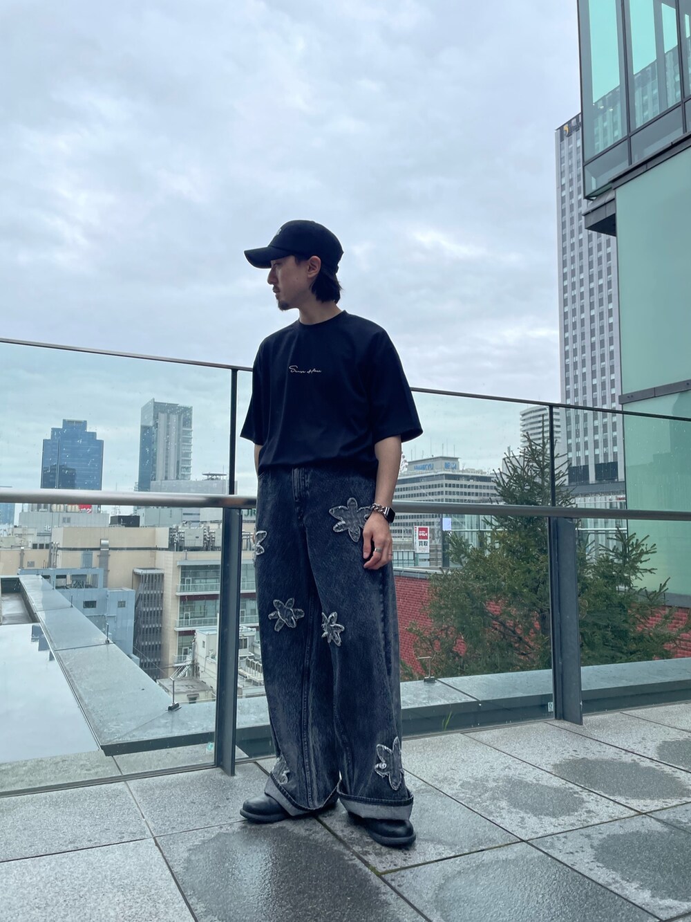 ブラック系のTシャツ/カットソー、ブラック系のデニムパンツを着用したメンズの春コーディネートの2枚目の写真