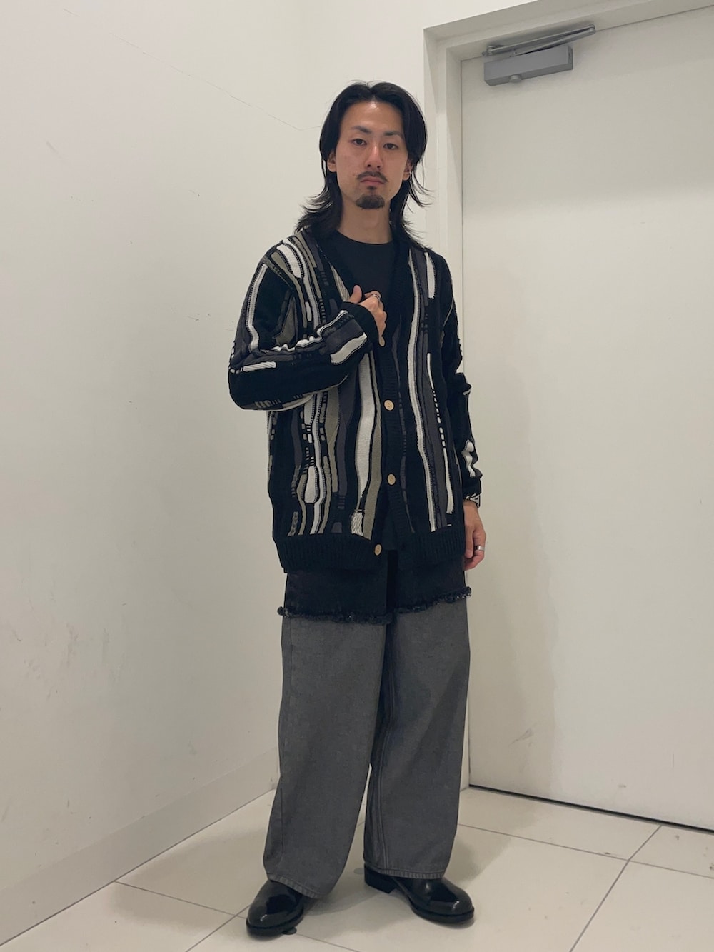 ブラック系のカーディガン/ボレロ、ブラック系のデニムパンツを着用したメンズの秋コーディネートの2枚目の写真