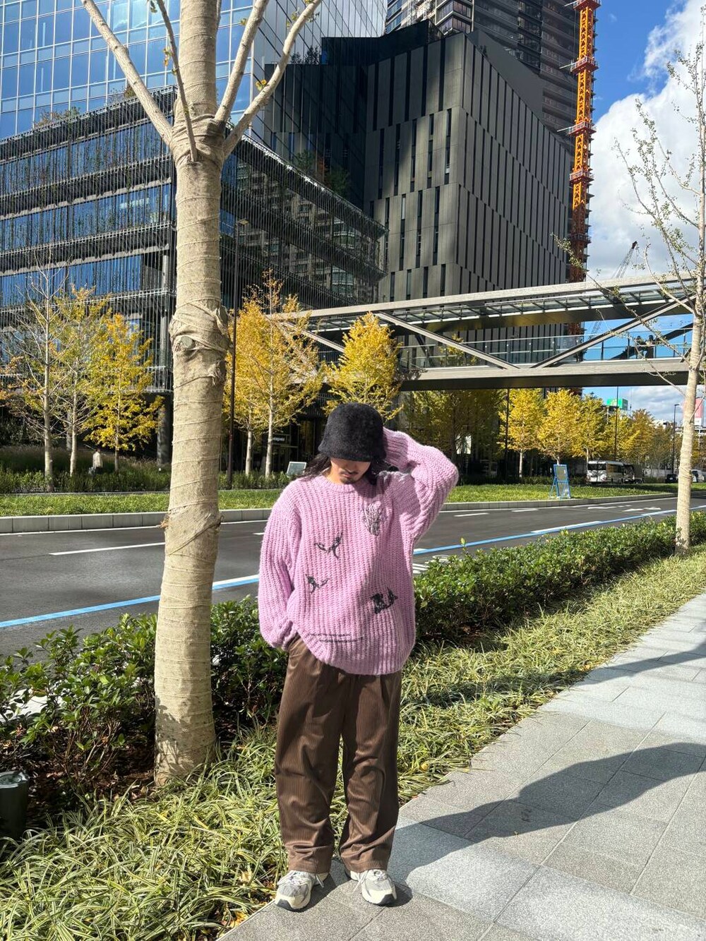 パープル系のニット/セーター、ブラウン系のその他パンツ、ブラック系のハットを着用したメンズの冬コーディネートの4枚目の写真