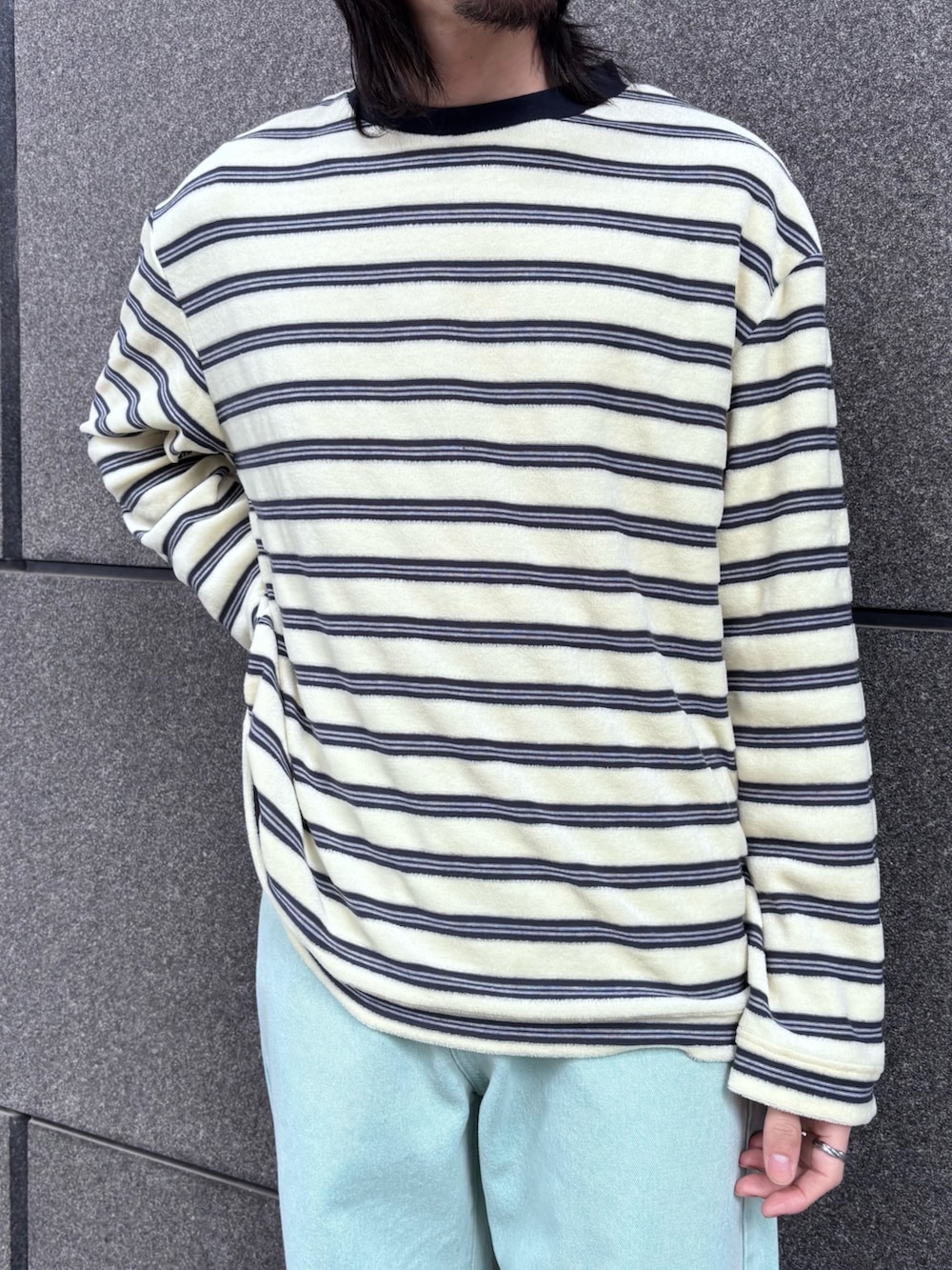 ベージュ系のTシャツ/カットソー、グリーン系のデニムパンツを着用したメンズの冬コーディネートの2枚目の写真