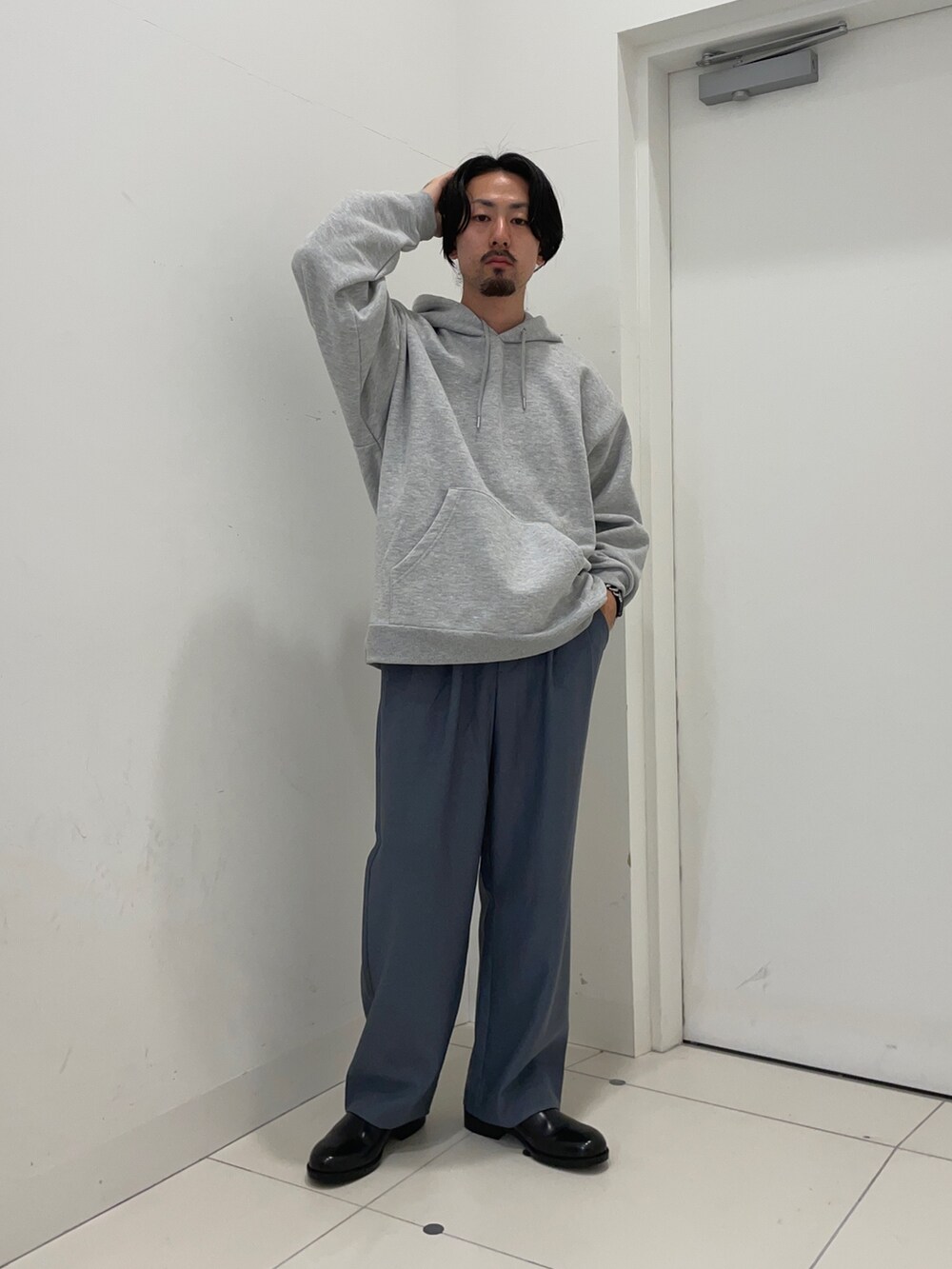 グレー系のパーカー、ブルー系のスラックスを着用したメンズの冬コーディネートの2枚目の写真