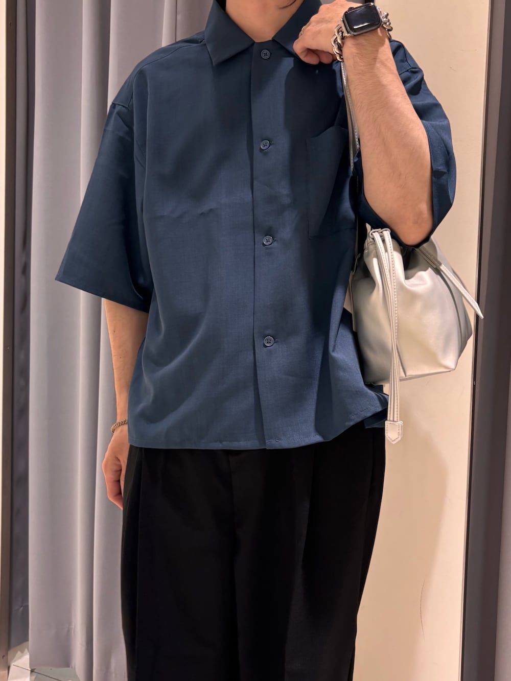 ブラック系のスラックス、ブルー系のシャツ/ブラウス、シルバー系のショルダーバッグを着用したメンズの春コーディネートの2枚目の写真