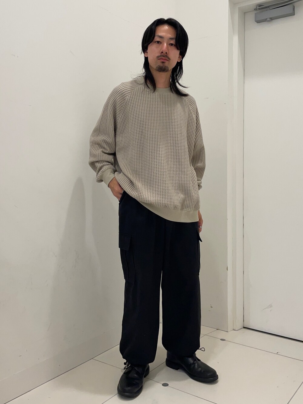 ベージュ系のスウェット、ブラック系のカーゴパンツを着用したメンズの秋コーディネートの2枚目の写真
