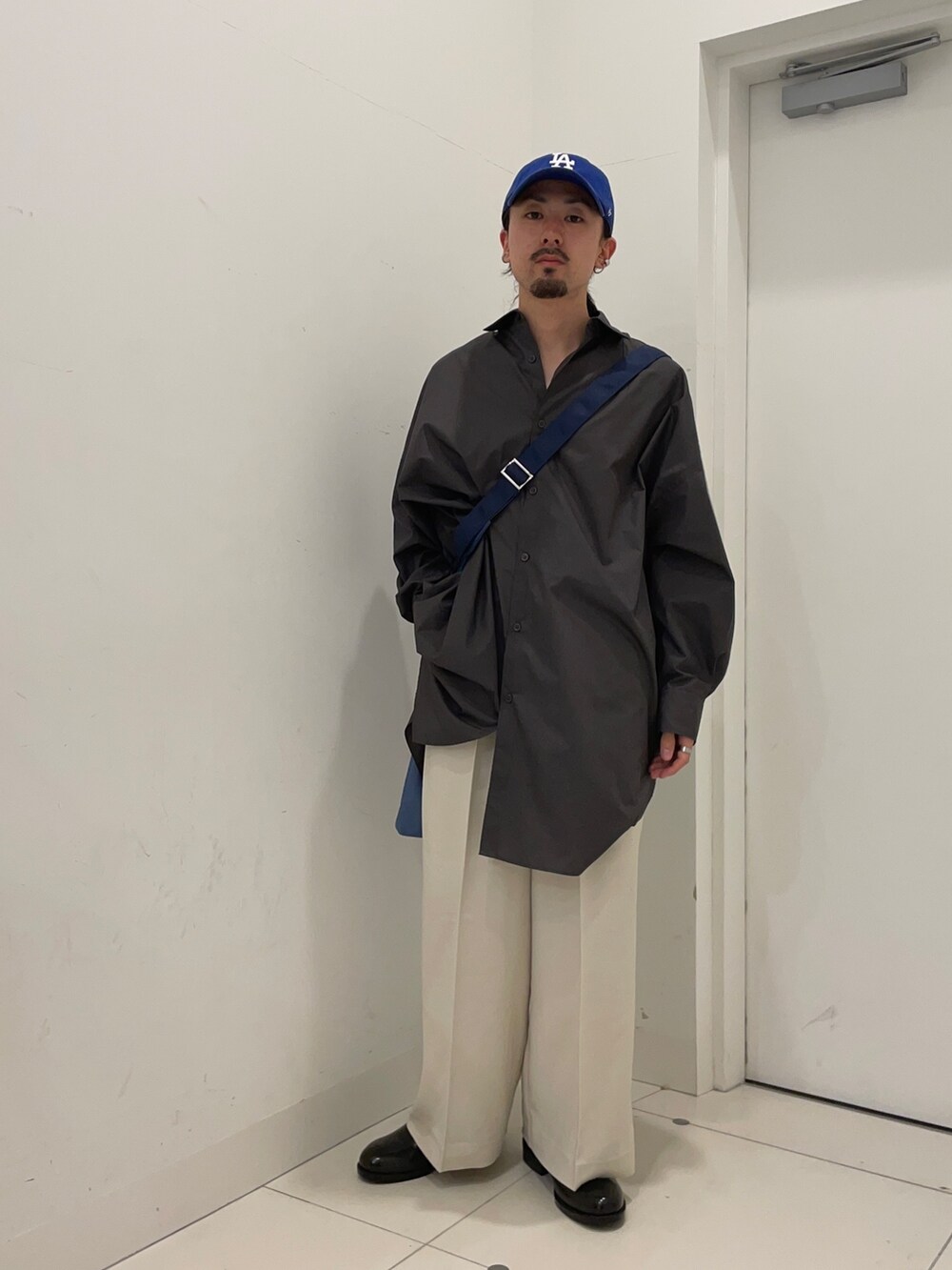 ホワイト系のその他パンツ、グレー系のシャツ/ブラウス、ブルー系のショルダーバッグを着用したメンズの冬コーディネートの2枚目の写真