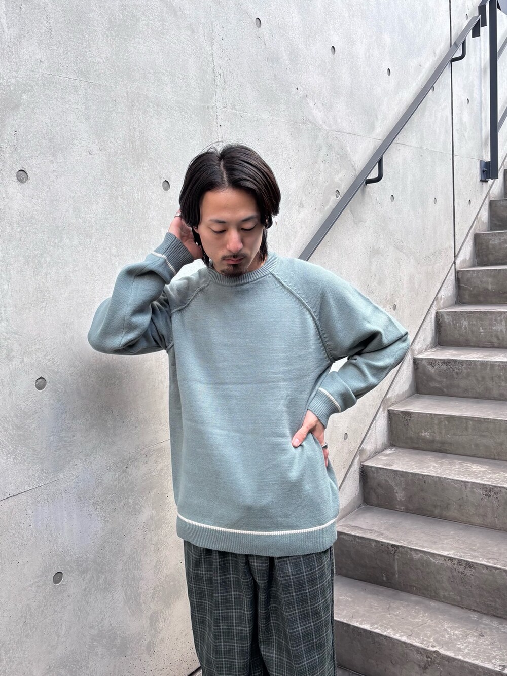 グリーン系のニット/セーター、グリーン系のスラックスを着用したメンズの秋コーディネートの5枚目の写真