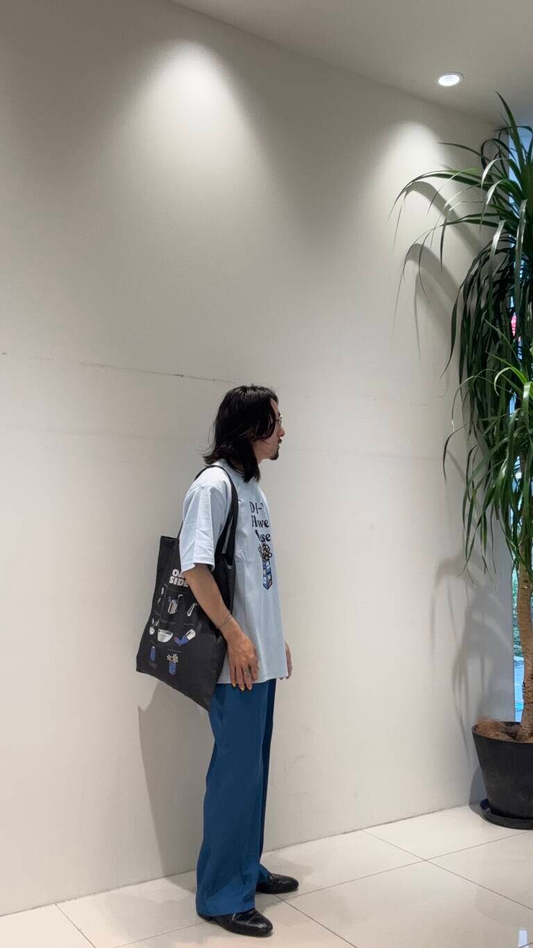 ブルー系のその他パンツ、ブラック系のトートバッグ、ブルー系のTシャツ/カットソーを着用したメンズの春コーディネートの4枚目の写真