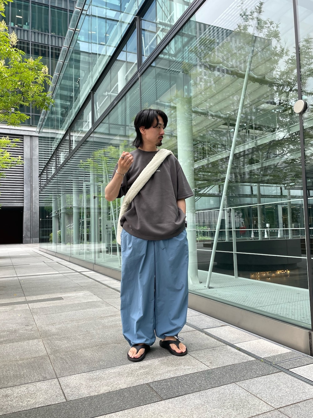 グレー系のTシャツ/カットソー、ブルー系のその他パンツ、ホワイト系のショルダーバッグを着用したメンズの夏コーディネートの2枚目の写真