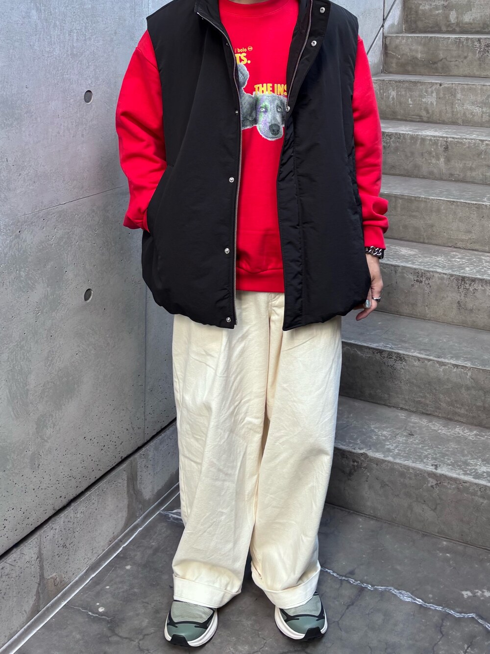 レッド系のスウェット、ブラック系のダウンベスト、ホワイト系のその他パンツを着用したメンズの秋コーディネートの3枚目の写真