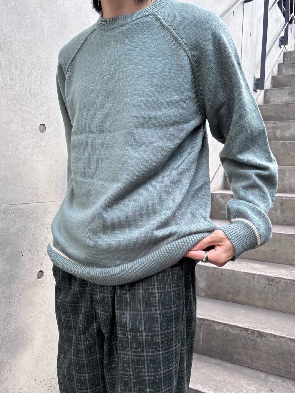 グリーン系のニット/セーター、グリーン系のスラックスを着用したメンズの秋コーディネートの4枚目の写真