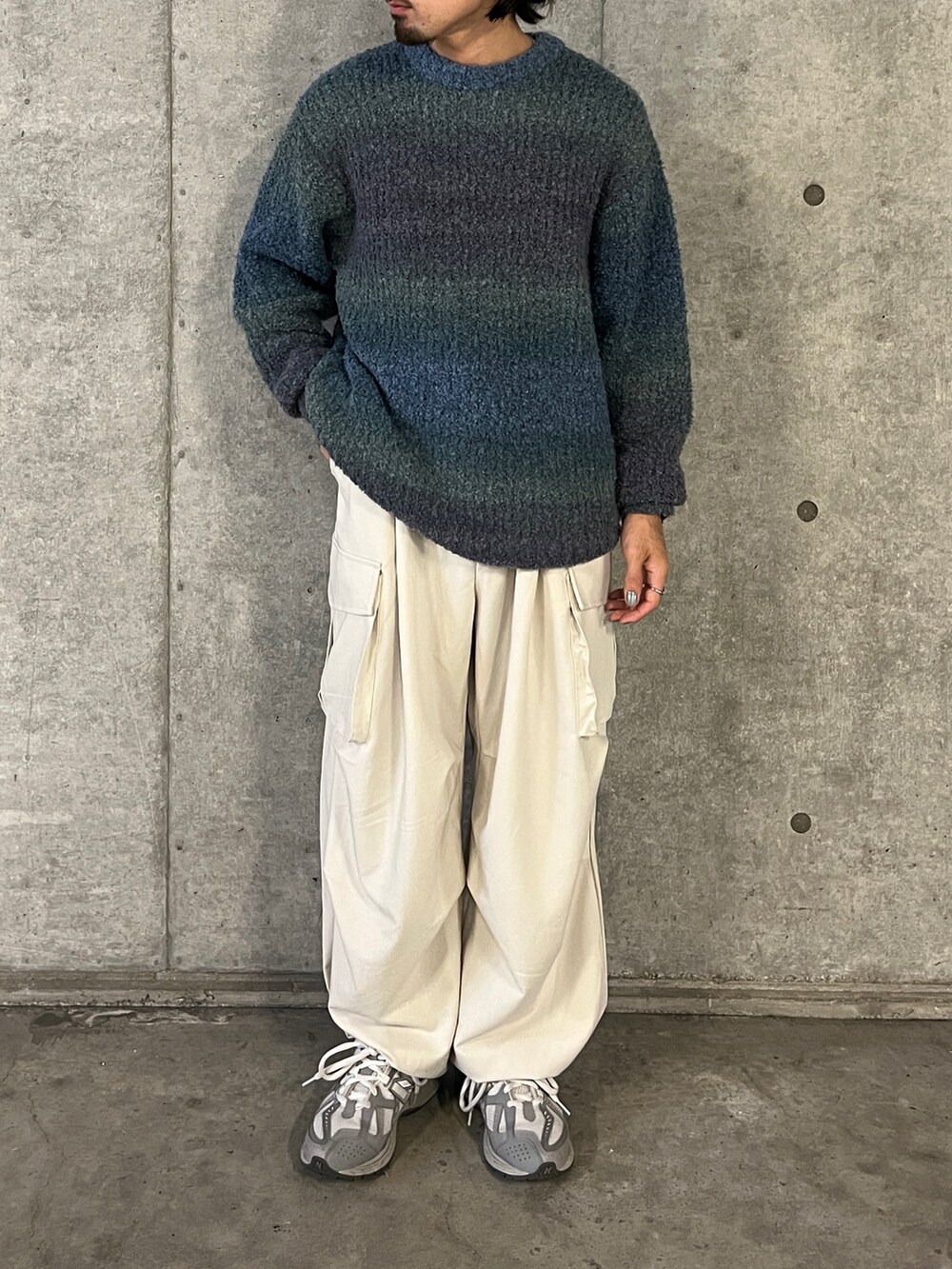 ブルー系のニット/セーター、ホワイト系のその他パンツを着用したメンズの秋コーディネートの3枚目の写真
