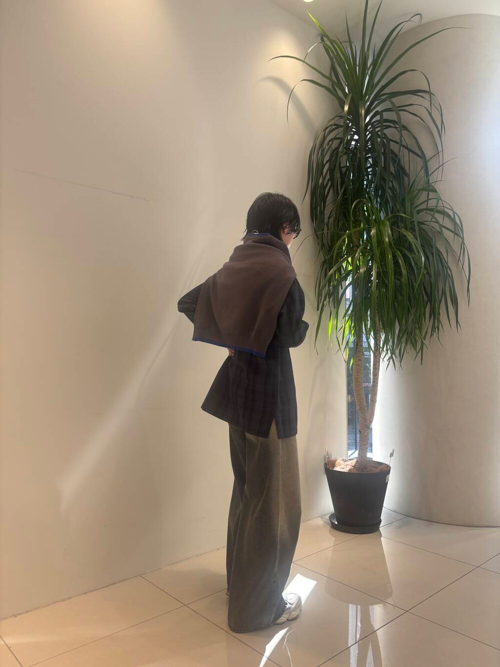 グレー系のニット/セーター、ブルー系のデニムパンツ、ブルー系のシャツ/ブラウスを着用したメンズの冬コーディネートの2枚目の写真