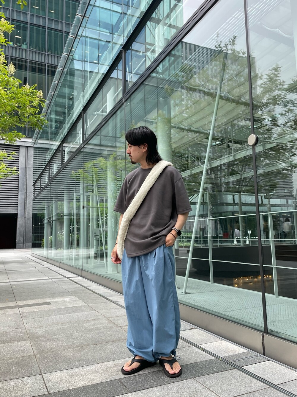 グレー系のTシャツ/カットソー、ブルー系のその他パンツ、ホワイト系のショルダーバッグを着用したメンズの夏コーディネートの3枚目の写真