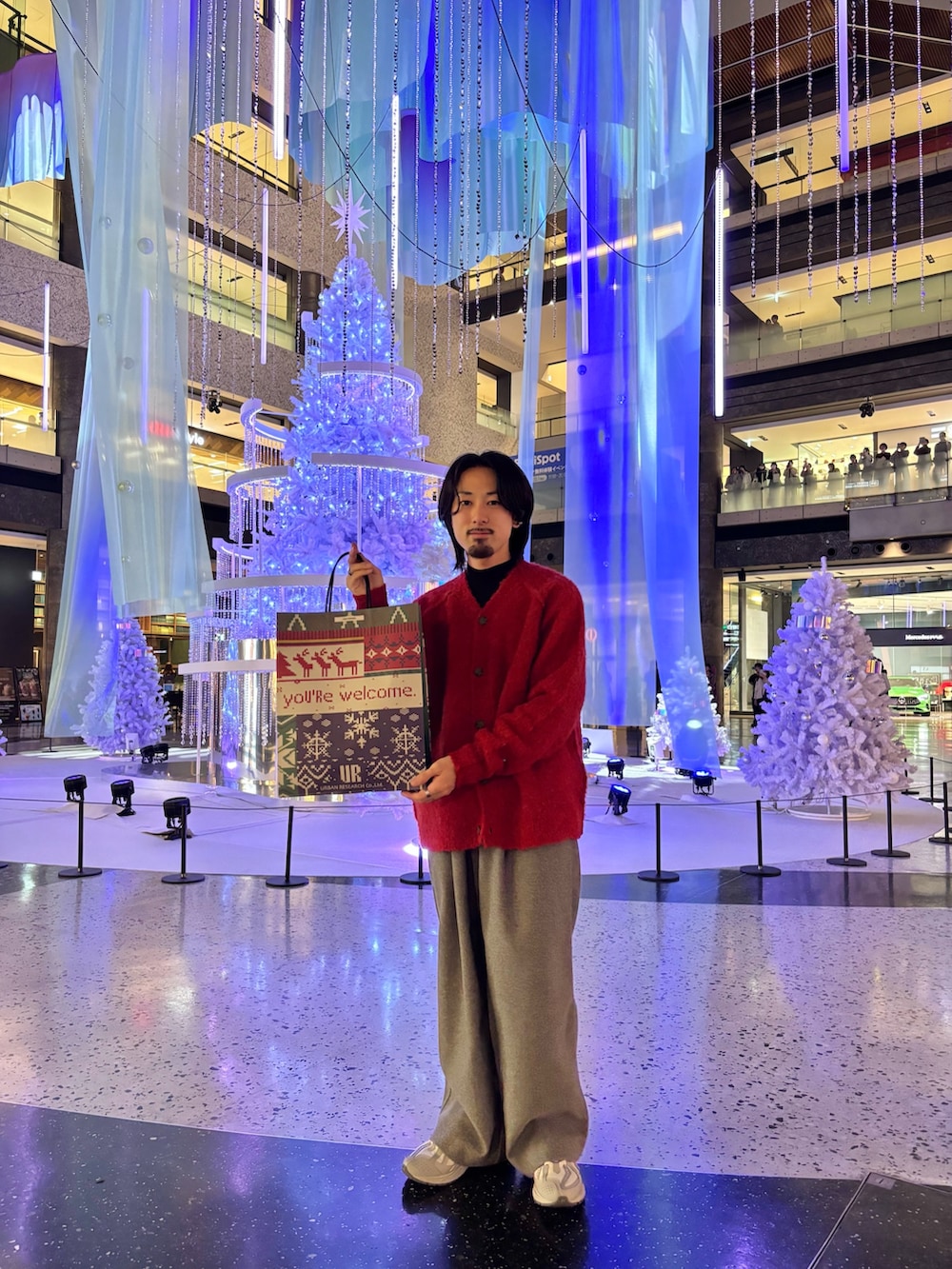 レッド系のカーディガン/ボレロ、グレー系のその他パンツ、ブラック系のニット/セーターを着用したメンズの冬コーディネートの2枚目の写真