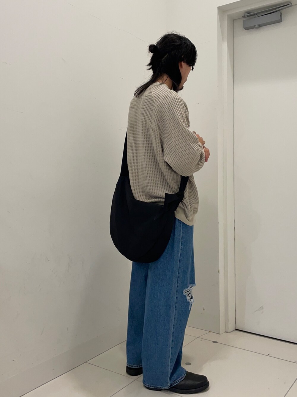 ベージュ系のスウェット、ブルー系のデニムパンツを着用したメンズの秋コーディネートの3枚目の写真