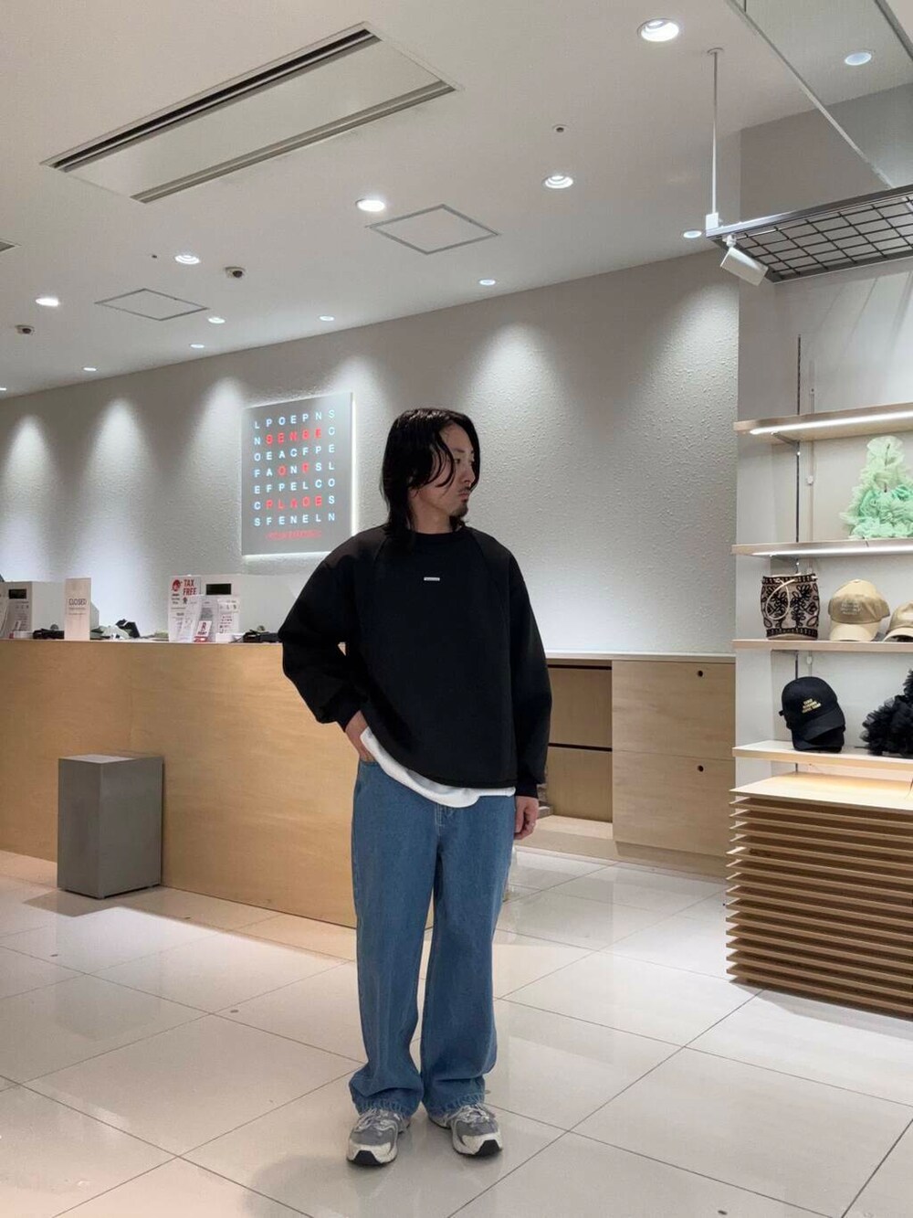 ブルー系のデニムパンツ、ブラック系のスウェットを着用したメンズの春コーディネートの2枚目の写真