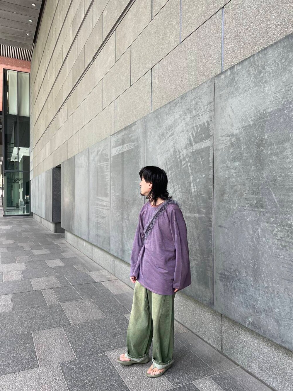 グリーン系のデニムパンツ、ブラウン系のTシャツ/カットソー、グレー系のスマホケース/カバーを着用したメンズの秋コーディネートの2枚目の写真