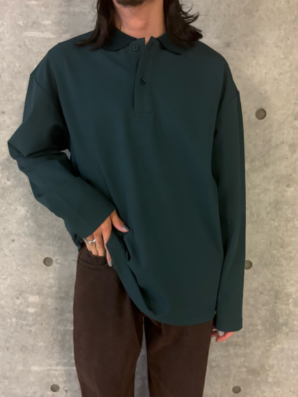 ブラウン系のデニムパンツ、グリーン系のポロシャツを着用したメンズの秋コーディネートの4枚目の写真