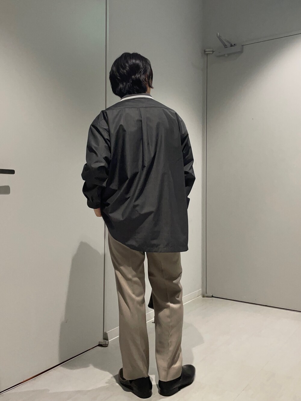 ブラック系のシャツ/ブラウス、ベージュ系のその他パンツ、ブラック系のショルダーバッグを着用したメンズの春コーディネートの2枚目の写真