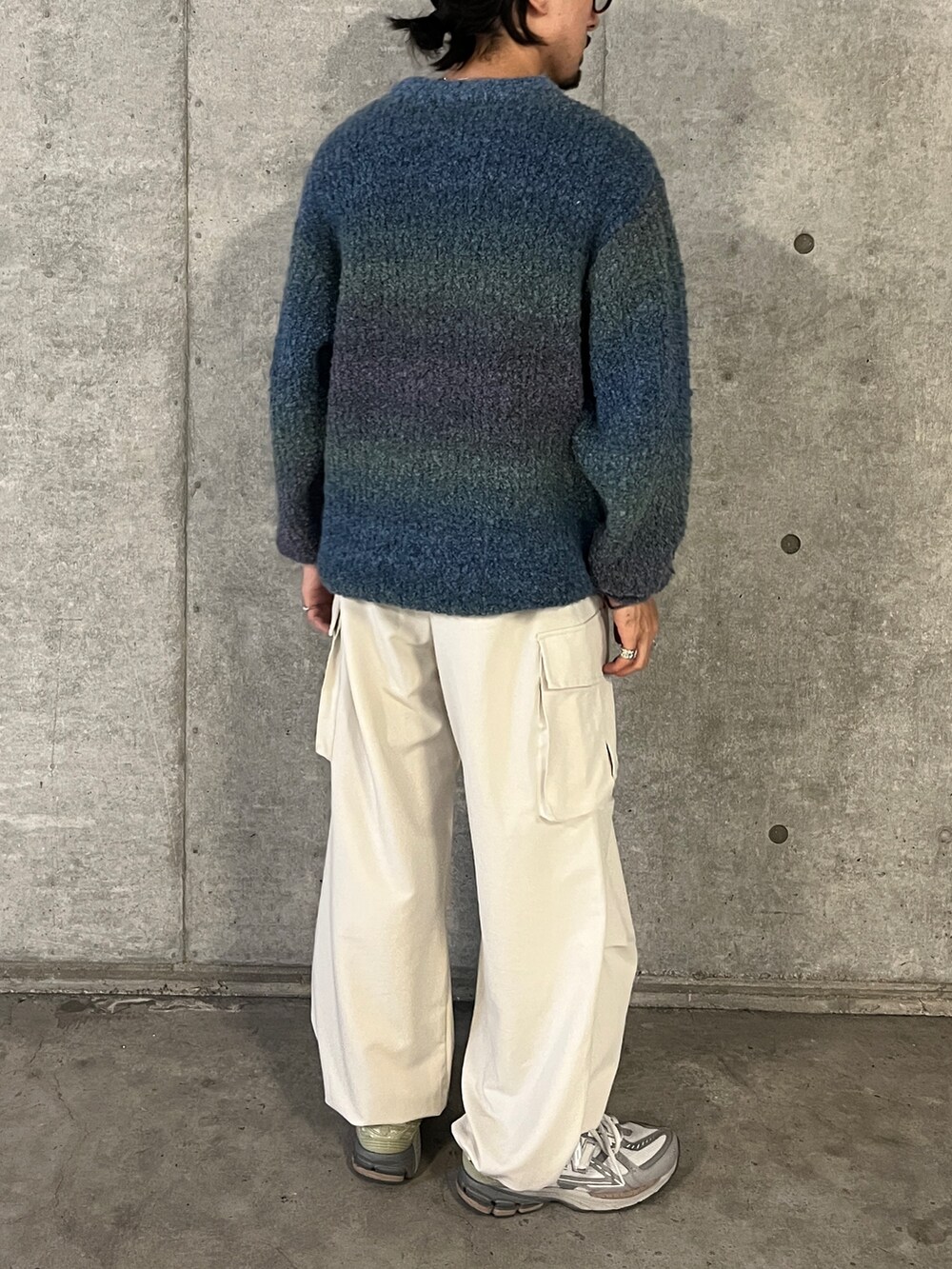 ブルー系のニット/セーター、ホワイト系のその他パンツを着用したメンズの秋コーディネートの2枚目の写真