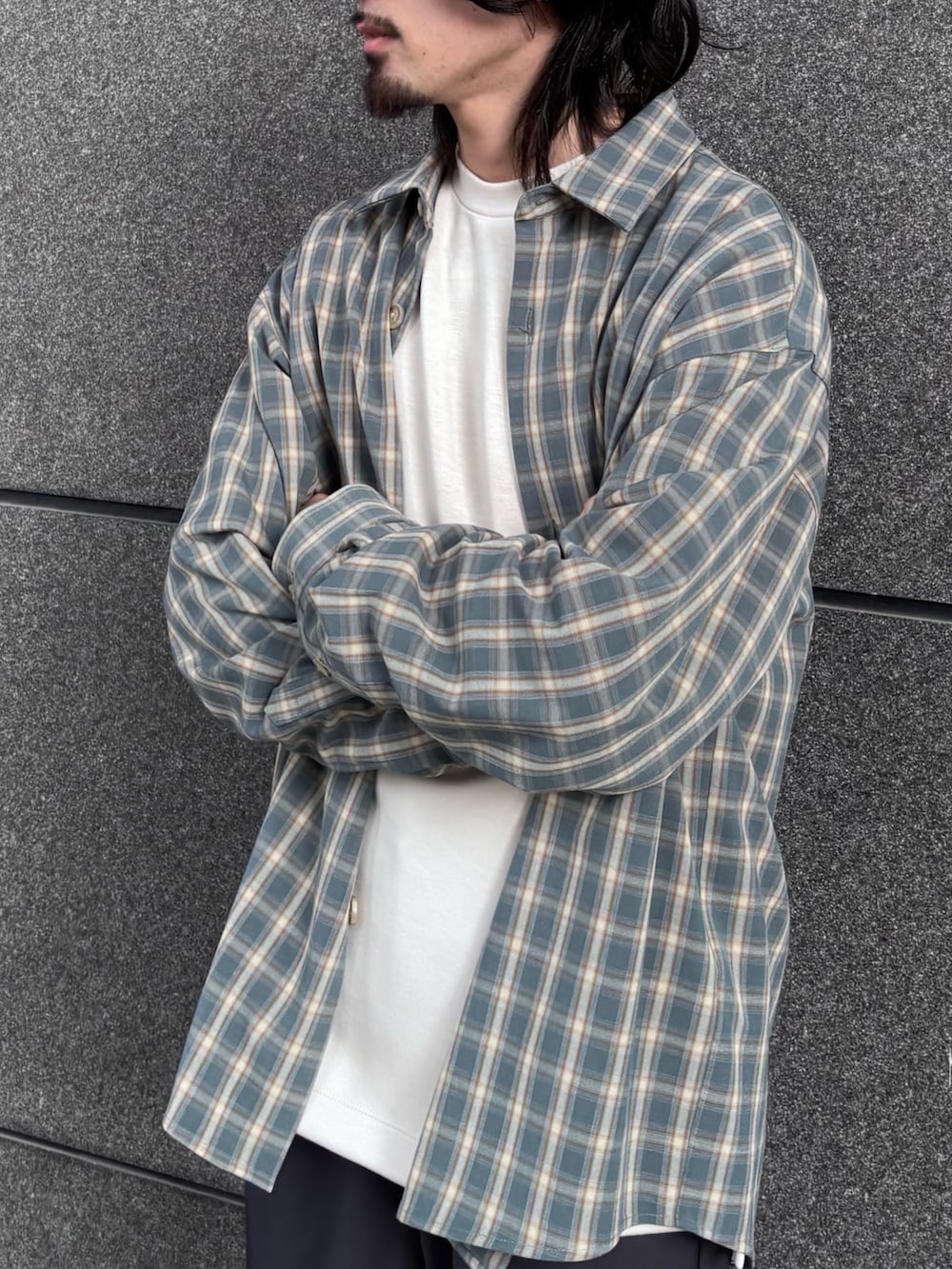 ホワイト系のTシャツ/カットソー、ブルー系のシャツ/ブラウス、グレー系のスラックスを着用したメンズの冬コーディネートの4枚目の写真