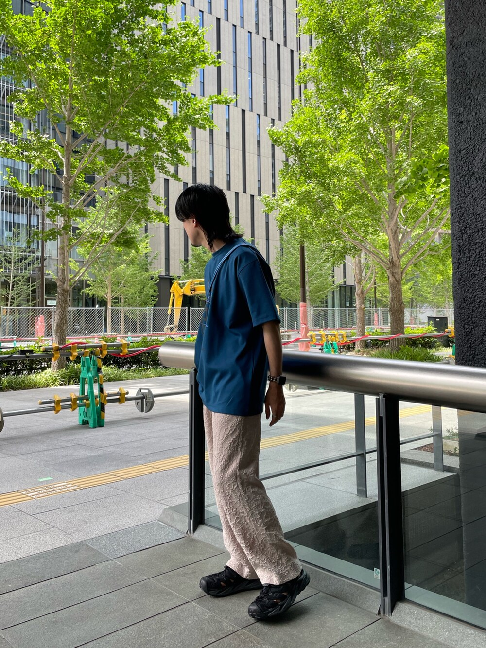 ブルー系のTシャツ/カットソー、ベージュ系のスラックスを着用したメンズの夏コーディネートの2枚目の写真
