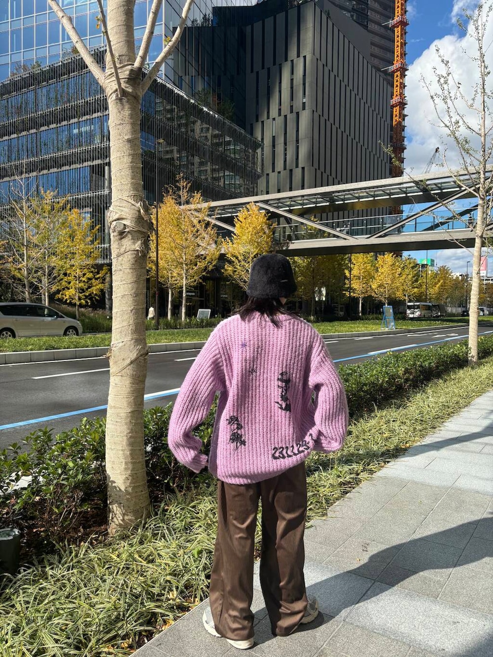 パープル系のニット/セーター、ブラウン系のその他パンツ、ブラック系のハットを着用したメンズの冬コーディネートの3枚目の写真