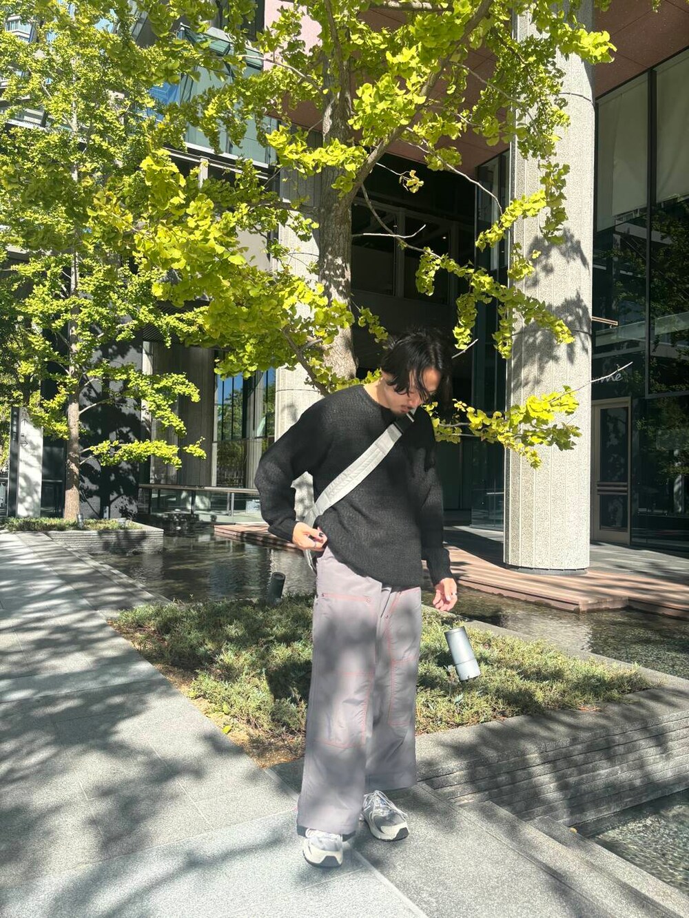 グレー系のショルダーバッグ、グレー系のその他パンツ、ブラック系のニット/セーターを着用したメンズの秋コーディネートの2枚目の写真