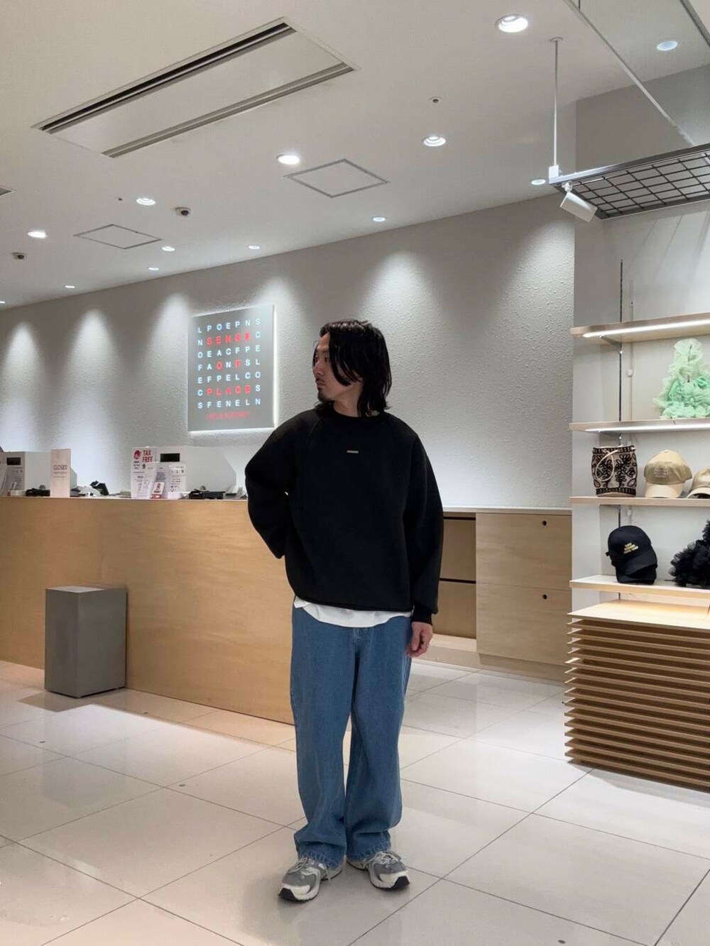 ブルー系のデニムパンツ、ブラック系のスウェットを着用したメンズの春コーディネートの3枚目の写真