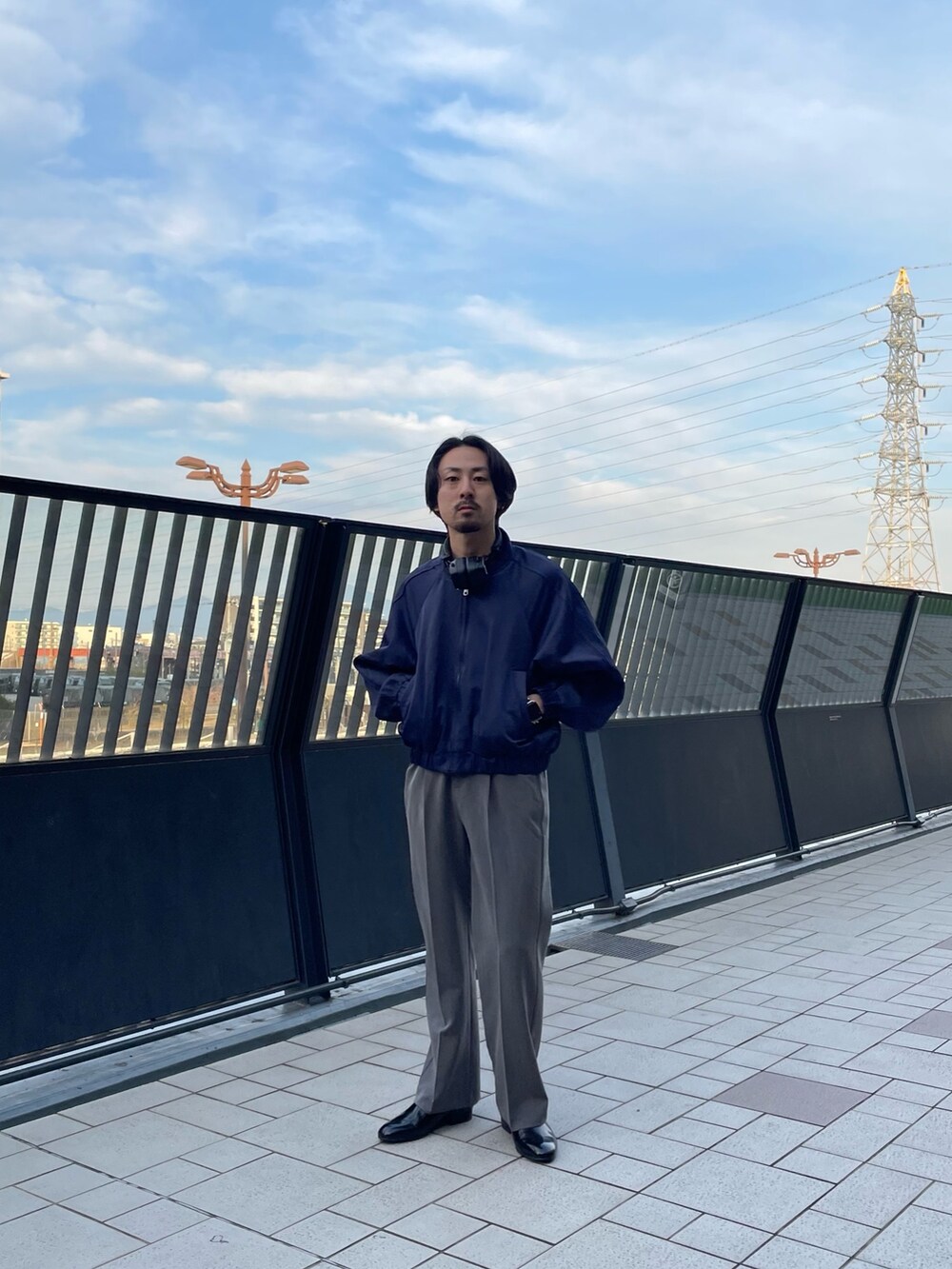 ブルー系のブルゾン、グレー系のスラックスを着用したメンズの春コーディネートの3枚目の写真