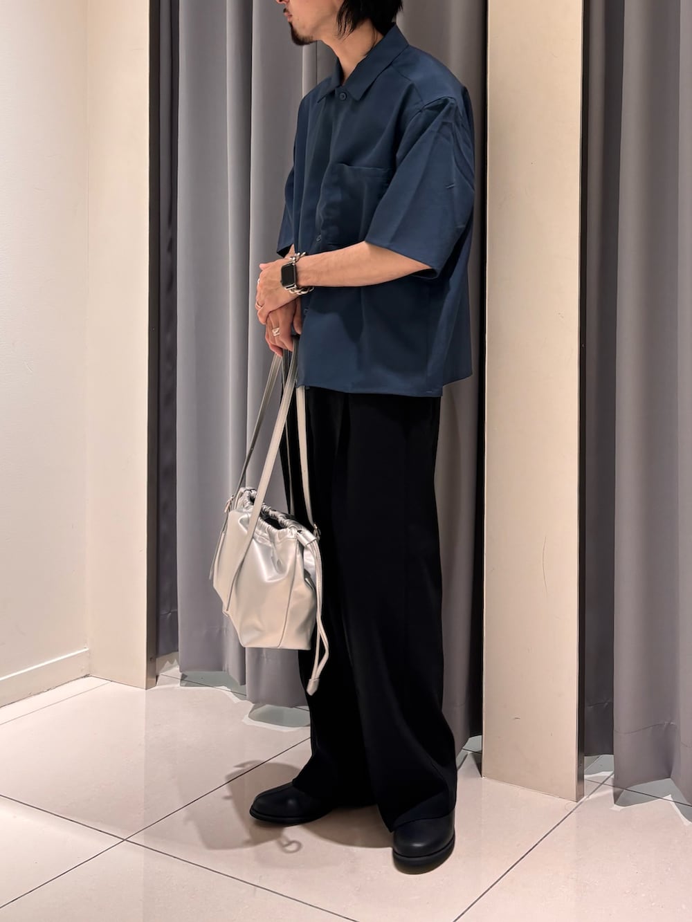 ブラック系のスラックス、ブルー系のシャツ/ブラウス、シルバー系のショルダーバッグを着用したメンズの春コーディネートの3枚目の写真