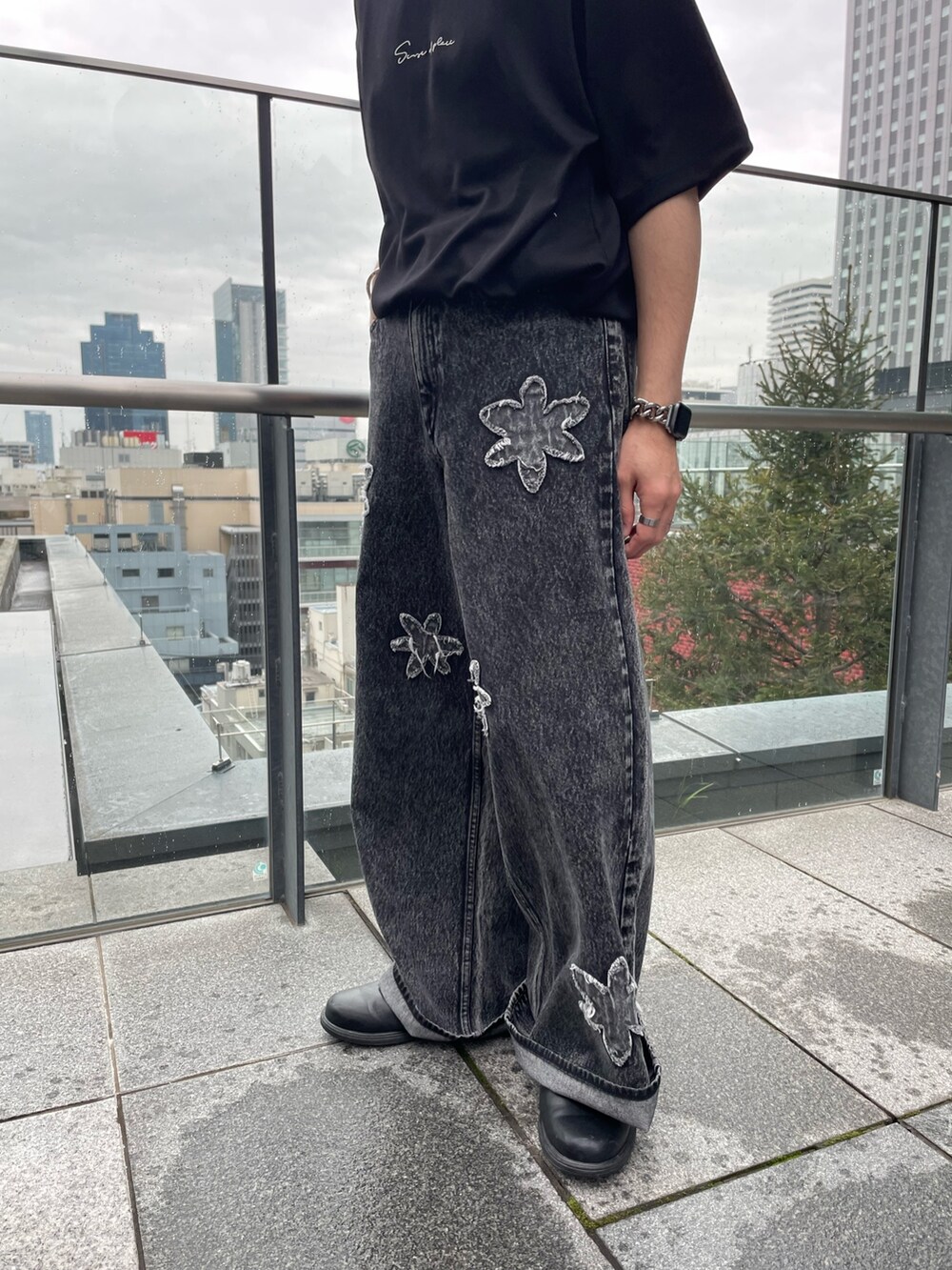 ブラック系のTシャツ/カットソー、ブラック系のデニムパンツを着用したメンズの春コーディネートの3枚目の写真