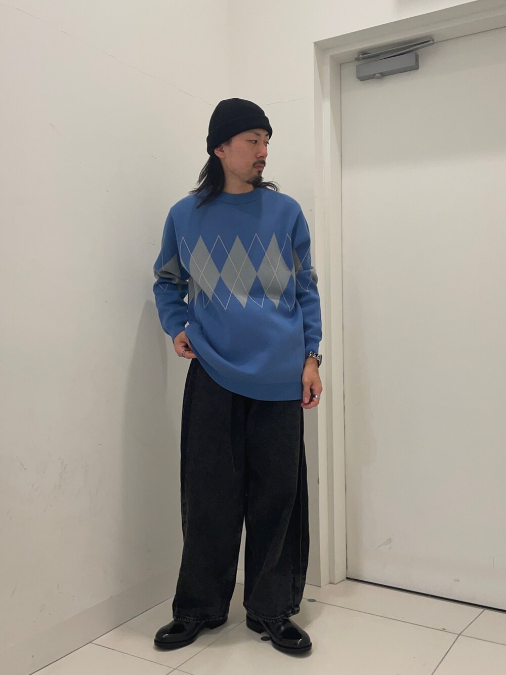 ブルー系のニット/セーター、ブラック系のデニムパンツを着用したメンズの冬コーディネートの2枚目の写真