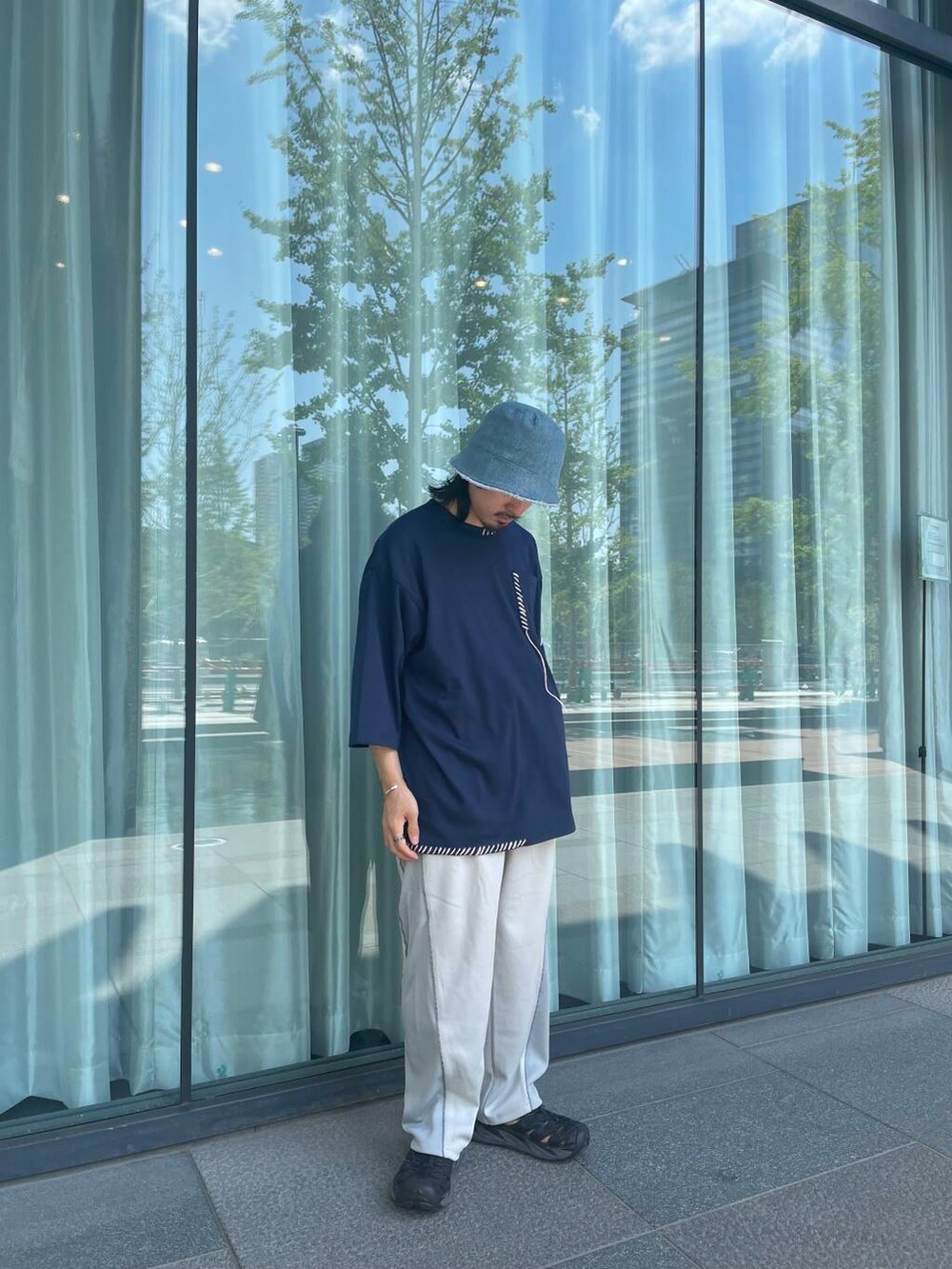 グレー系のその他パンツ、ブルー系のTシャツ/カットソー、ブルー系のハットを着用したメンズの夏コーディネートの3枚目の写真